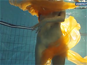 Yellow and red clothed nubile underwater